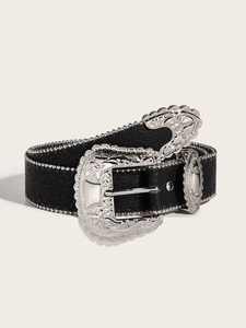 Close-up of black leather belt with silver studs, embossed pattern and large carved buckle