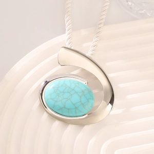 Close-up of turquoise stone pendant with silver metal frame on white woven rope chain