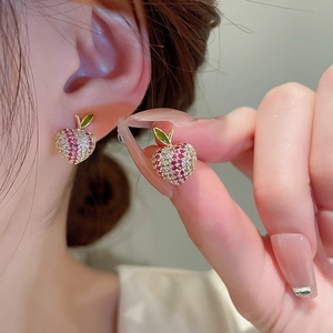 Detailed close-up of apple-shaped stud earrings with green enamel leaves and zircon stones