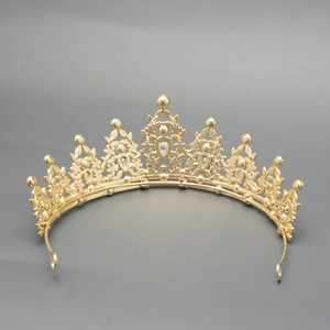 Detailed close-up of golden luxury tiara featuring intricate floral and leaf hollow patterns