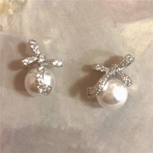 Elegant silver bow earrings with zircon and pearls for a minimalist fashion look