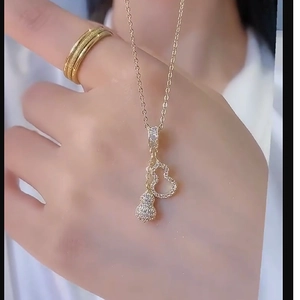 Elegant gold gourd pendant necklace with pave-set zircon stones on a fine link chain