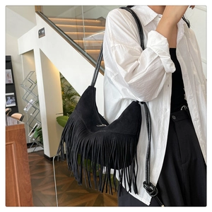 Détail du sac hobo en daim noir avec de longues franges et une bandoulière en cuir nouée
