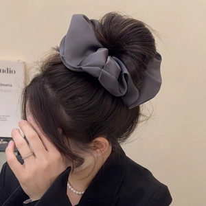 Oversized dark grey satin scrunchie with ballet style bow on an elegant model hairstyle