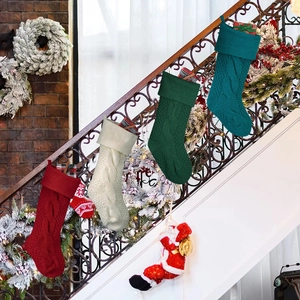 Knitted Christmas stockings set in red, ivory, and green hanging on festive staircase