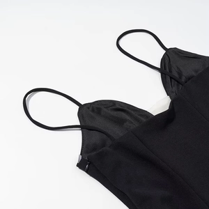 Detail of thin straps and side zipper on a black satin polka dot dress bodice