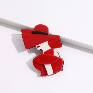 Close-up of stylish acrylic brooch featuring a lady in red hat and matching gown