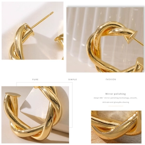 Macro shot of 18K gold twist earrings showing 360-degree mirror polishing detail