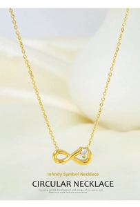 Detailed macro view of gold infinity necklace with a clear cubic zirconia on satin fabric