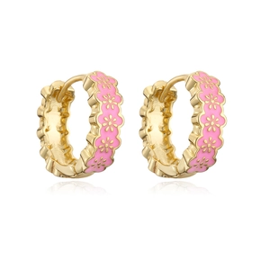 Detail of gold-plated huggie hoop earrings with pink enamel and floral patterns
