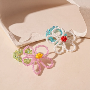 Handmade flower glass beaded rings in pink and white on a minimalist stone tray