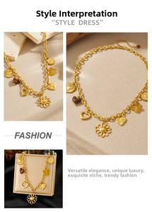Detail of vintage gold plated necklace with hollow sunflower, heart and coin charms