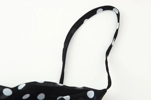 Detail of polka dot ruffle dress straps showing stitching and chiffon fabric texture