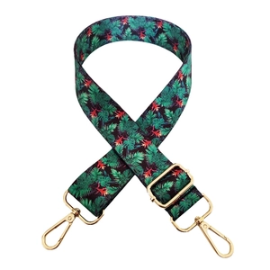 Detail of adjustable polyester bag strap featuring a tropical green palm leaf pattern