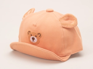 Detailed side view of a cotton baby baseball cap in orange-pink with cute 3D bear ears
