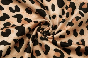 Macro view of leopard print fabric showing detailed knit texture and soft drape