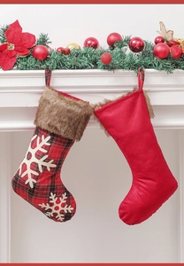 Chaussettes de Noël à carreaux avec motifs flocons suspendues à une cheminée décorée