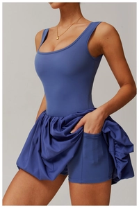 Detail view of navy blue tennis dress featuring functional side pockets and pleated hem