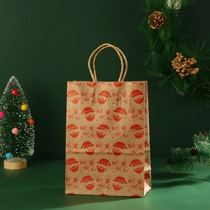 Detail of kraft paper Christmas gift bag with Santa Claus prints and twist handles