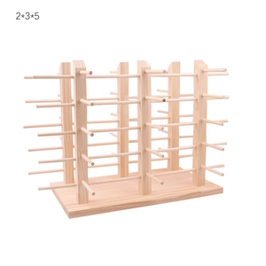 Macro detail of the wooden eyewear display stand showing natural texture and spool pillars