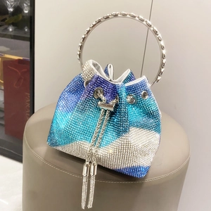 Dettaglio borsa a secchiello con strass sfumati blu, frange di cristallo e manico in metallo