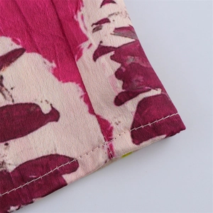 Macro shot of satin fabric with pink print and neat single-needle hem stitching detail