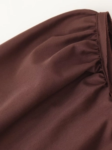 Dettaglio ravvicinato del tessuto in cotone marrone scuro con design a pieghe