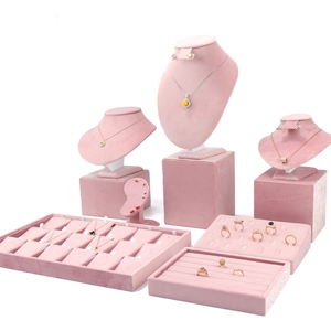 Detailed set of pink velvet necklace busts and jewelry display trays on white background