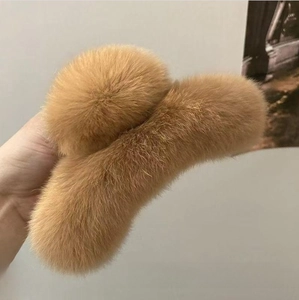 Macro detail of the plush texture and caramel brown fur on this large hair claw clip