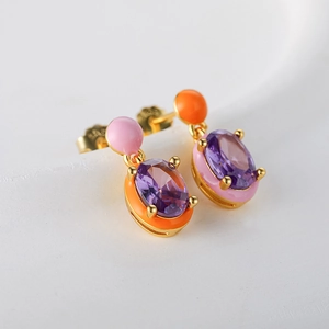 Macro view of vintage gold S925 silver earrings with purple gems and colorful enamel