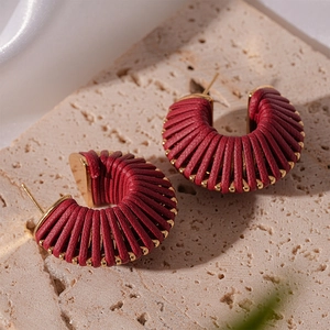 Detailed close-up of dark red faux leather thread-wrapped geometric hoop earrings