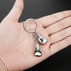 Polished silver stainless steel boxing glove keychain set on a textured background