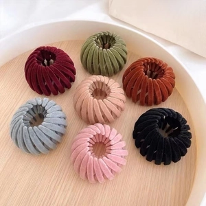 Detailed view of 7 colors velvet expandable bird nest hair clips in a wooden tray