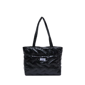 Chic black quilted tote bag with glossy finish and fashion instinct label on white background