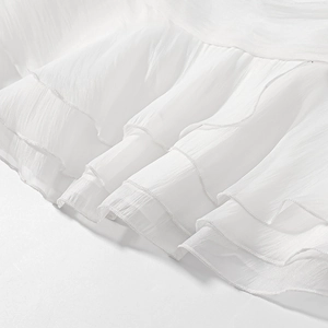 Detailed macro view of white layered chiffon ruffles with elegant pleated texture
