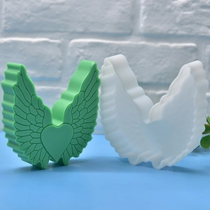 DIY silicone mold for heart wing candles and soap showing finished green feather craft