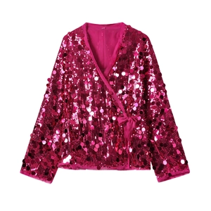 Detail of fuchsia sequin wrap top featuring a V-neck design and glossy long sleeves