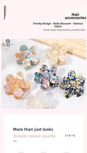 Detail view of five marble texture acrylic flower hair claws in assorted vintage colors