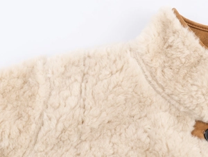 Detail shot of the plush faux shearling collar and premium suede fabric stitching