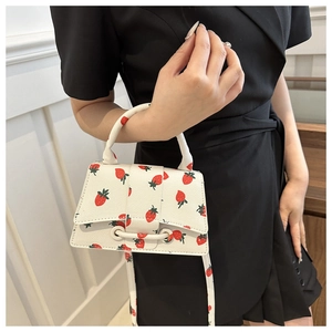 Detail van witte mini crossbodytas met aardbeienprint en smalle schouderband voor dames