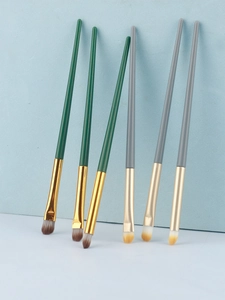 Detail view of 6-piece eye makeup brush set with green and grey handles and metallic tubes