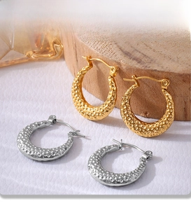 Detailed macro of gold and silver PVD plated earrings with hammered texture finish