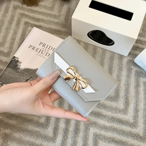 Short tri-fold light grey women's wallet with white contrast trim and gold bow buckle