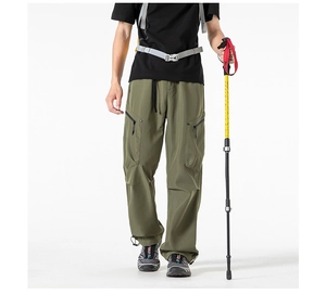 Close-up of olive green cargo pants showing side zipper pocket and drawstring cuffs
