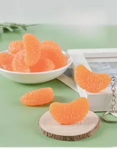 Realistic PVC orange slice keychain with detailed texture on a green background