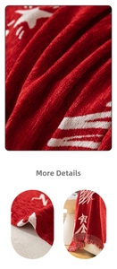 Detail of red knitted Christmas sofa throw with white star patterns and fringed edges