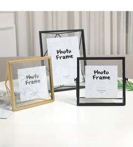 Détail de cadres géométriques en métal or et noir avec supports triangulaires