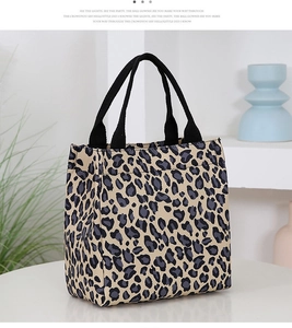 Close-up of leopard print canvas tote bag with reinforced handles on a clean desk