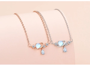 Close-up of rose gold and silver planet necklaces with blue stone and teardrop zircon