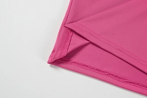 Gros plan du tissu en tricot rose avec coutures à double aiguille et texture lisse